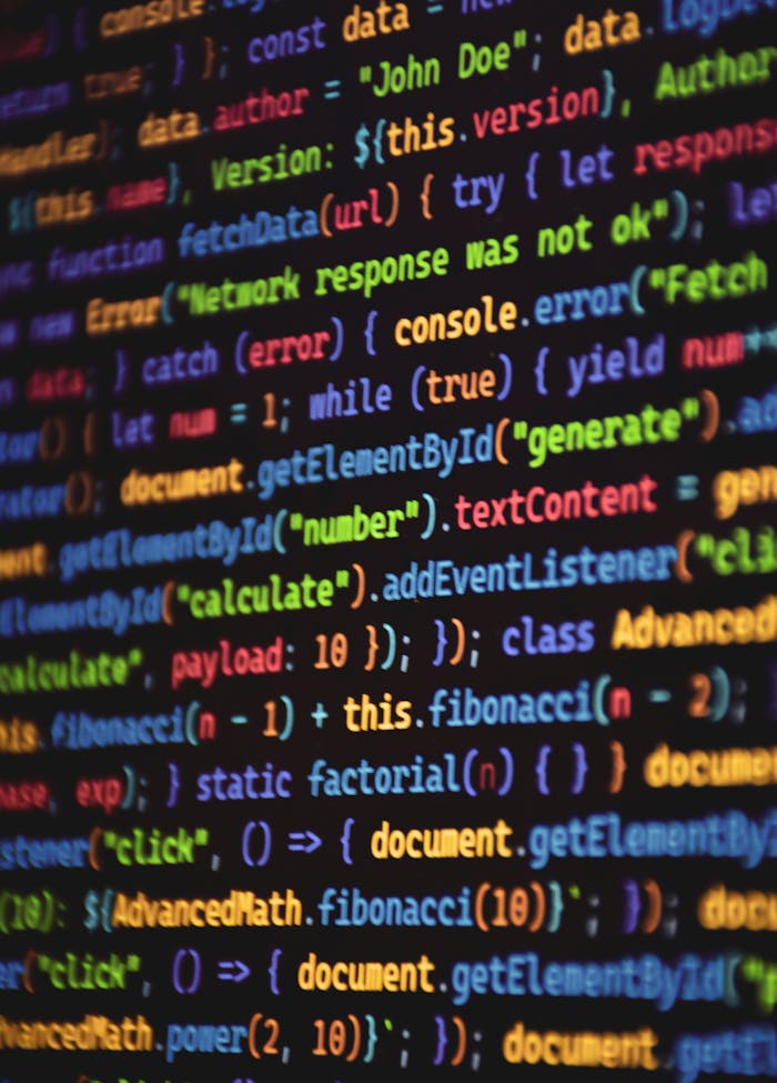 about-img-01 Close-up of vibrant colored JavaScript code showing functions and syntax on a dark screen.